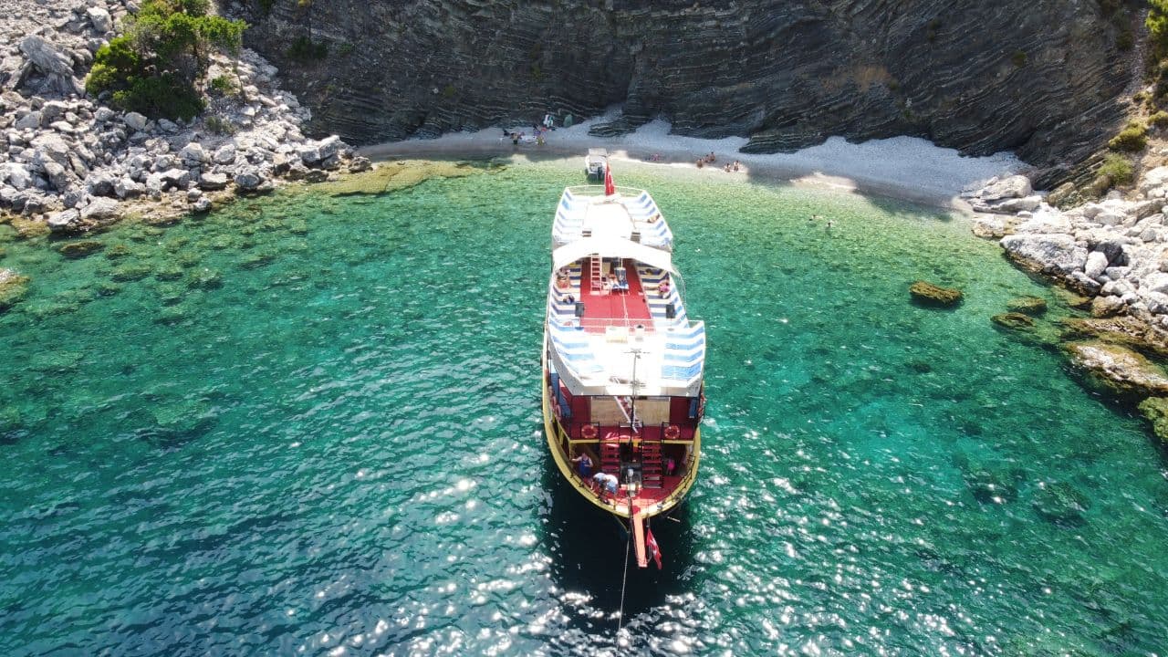 Hidden cove stop on a Marmaris boat tour — aerial view of the gulet in a secluded turquoise bay