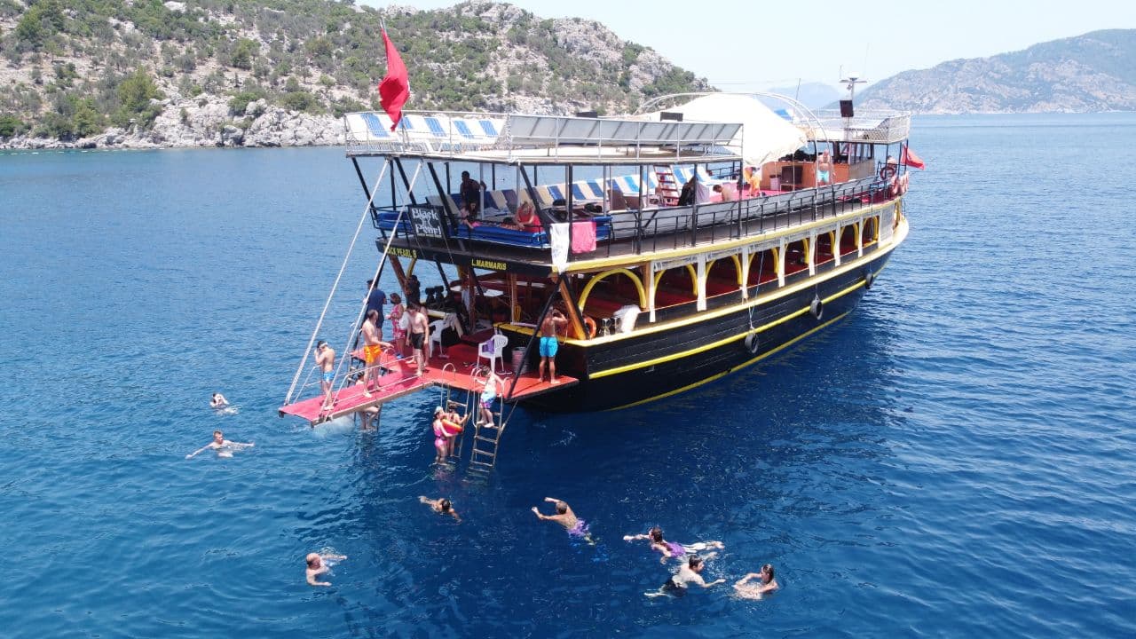 Marmaris boat tour swim stop — guests swimming next to the traditional gulet in the crystal-clear Aegean Sea