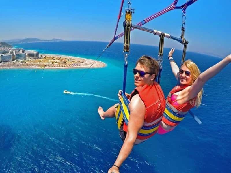 Couple parasailing over Marmaris coastline with turquoise water below